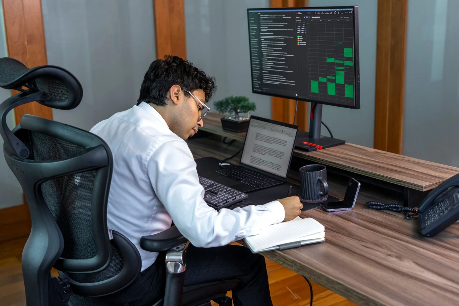Finance professional reviewing business data and records at an office workstation.