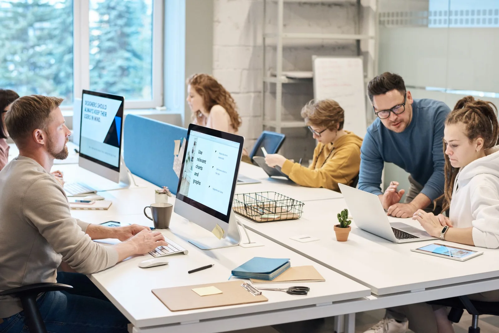 Digital quality team collaborating in front of a computer.