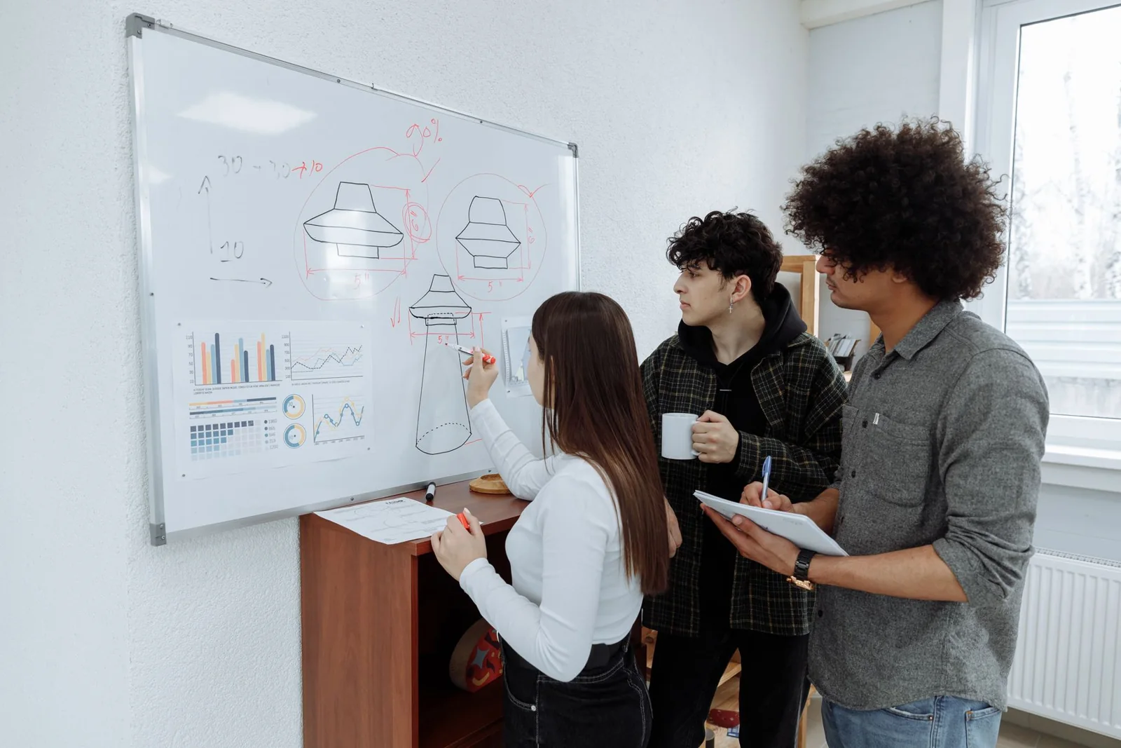 Product team brainstorming and mapping an invention on a whiteboard